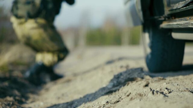 Soldiers' feet in army combat boots quickly get out of the military vehicle.