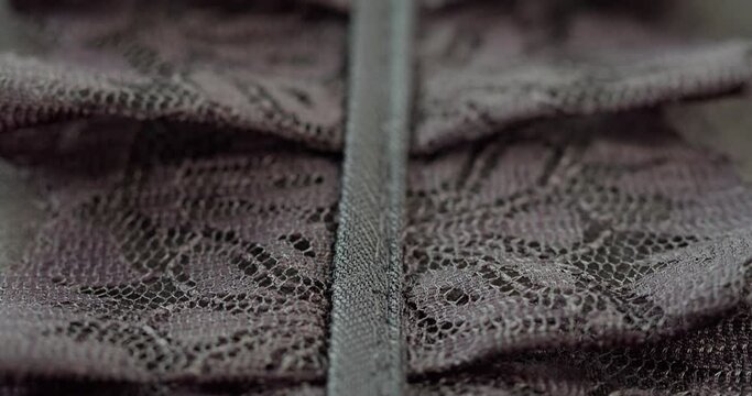 Black lace ruffles close-up. Sewing evening guipure dress. Handmade tailoring, professional clothing concept. Abstract background.