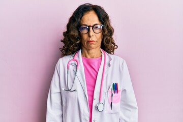 Middle age hispanic woman wearing doctor uniform and glasses skeptic and nervous, frowning upset...