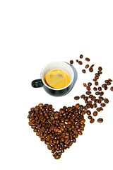 Small black heart shaped coffee cup with scattered beans on a white background. Front view. Isolate. Lifestyle.