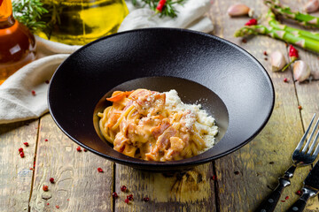 Spaghetti Carbonara with bacon on wooden table