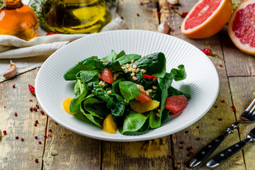 salad with citrus and spinach on wooden table
