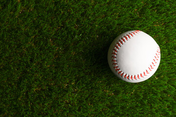 Close-up. Baseball ball on a green sports arena. There are no people in the photo. There is an empty space for insertion. Sports games, baseball, outdoor activities, healthy lifestyle.