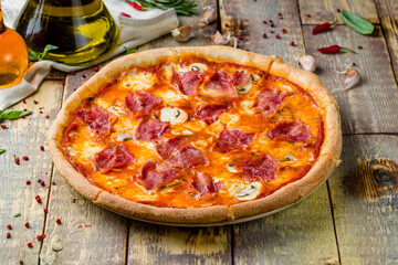 Pizza with ham and mushrooms on wooden table