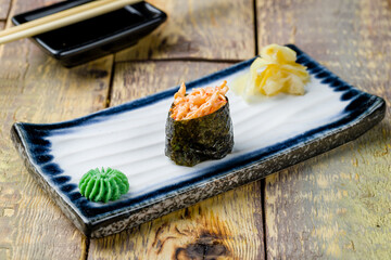 Gunkan sushi with spicy crab on wooden table