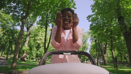 Happy woman playing peek-a-boo with her baby, having fun walking outdoors
