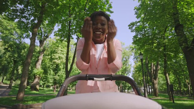 Happy woman playing peek-a-boo with her baby, having fun walking outdoors