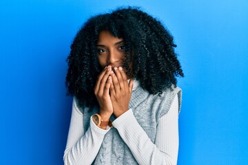 African american woman with afro hair wearing casual winter sweater laughing and embarrassed giggle...