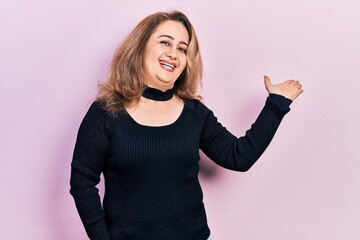 Middle age caucasian woman wearing casual clothes smiling cheerful presenting and pointing with palm of hand looking at the camera.