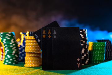 Casino. Online casino. Black poker cards with gold and silver embossing and stacks of multi-colored...