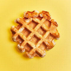  Single delicious waffle over yellow background