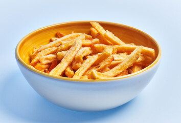  Bowl of french fried potatoes over blue background