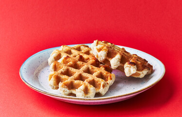  Plate of delicious waffles over red background