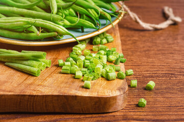 Whole and chopped fresh green beans on a cutting board.Bowl of green beans .Fresh Asparagus Beans For Eating.Salad ,Wooden Background ,Spinach Salad ,Healthy Fresh Food.Healthy and fresh food.
