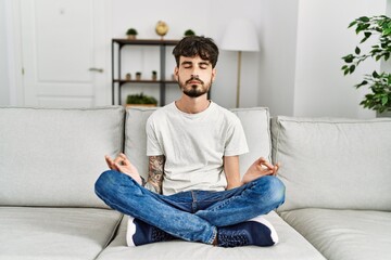 Young hispanic man concentrate meditating at home