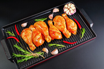 Raw Marinated chicken meat leg swith spices for cooking for BBQ dark background. Top view.Convenience food, precooked.Copy space.
