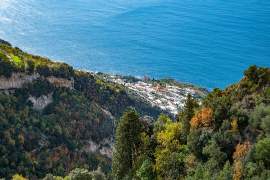The Italian village of Praiano, seen from above, from the Path of the Gods (Sentiero degli Dei) along the scenic Amalfi Coast of Italy, with the blue Tyrrhenian Sea and blue sky and clouds