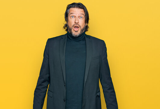 Middle age handsome man wearing business clothes afraid and shocked with surprise expression, fear and excited face.
