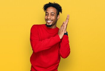Young african american man with beard wearing casual winter sweater clapping and applauding happy...