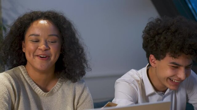 Happy attractive African-American a young couple of zoomers shopping online and entering credit card details into laptop. after the purchase, they rejoice and have fun. Slow motion.