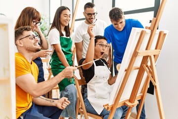 Group of people smiling happy and looking draw of partner at art studio.