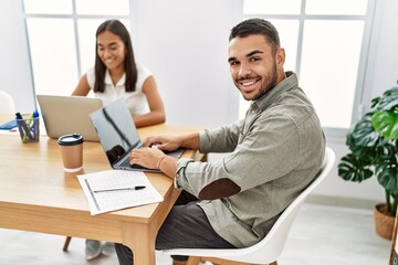 Two latin business workers smiling happy working at the office.