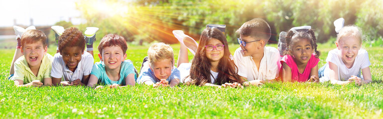 Portrait of children who are posing lying in the park. High quality photo - obrazy, fototapety, plakaty