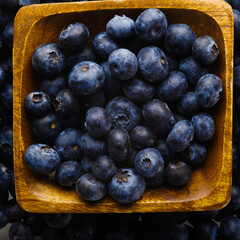 Close-up. Blue fresh blueberries in a yellow bowl. High angle view. Delicious vitamin product, juice, fresh, pie filling, sauces. Advertising. There are no people in the photo. Background Texture