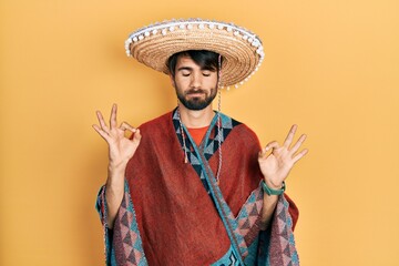 Young hispanic man holding mexican hat relax and smiling with eyes closed doing meditation gesture...
