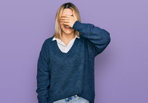 Young caucasian woman wearing casual clothes smiling and laughing with hand on face covering eyes for surprise. blind concept.