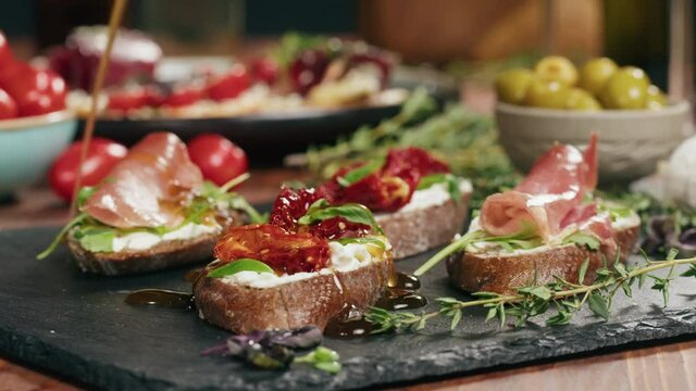 Italian restaurant with traditional food, Spanish cuisine, delicious tapas and white wine, bruschetta with cheese, olives dry tomatoes and tasty sandwich bar appetizer, buffet high cuisine table