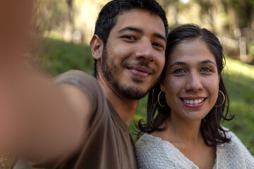Naklejka premium Two Latin American friends take a picture in the open air. Friendship concept