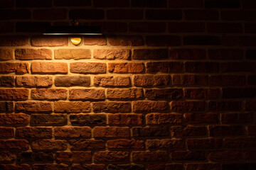 Brick wall illuminated by warm light from a lamp