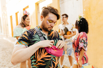 Care during Carnival. Man using sunscreen during carnival block