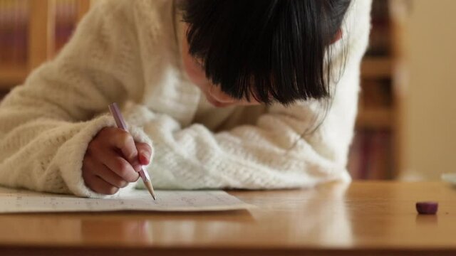 冬の家のリビングで宿題をしている可愛い子供