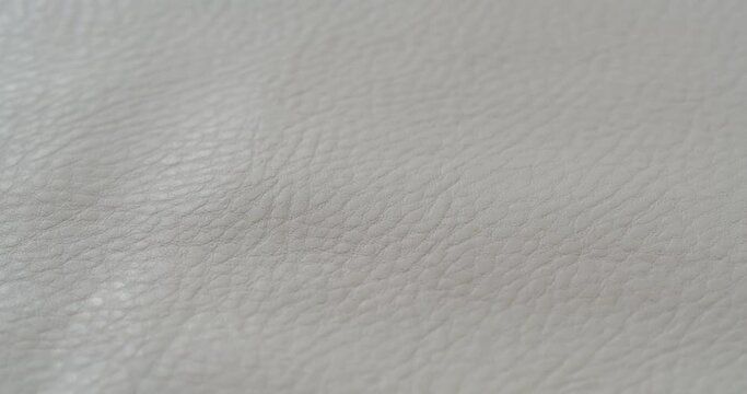 White leather close-up. Macro shooting of natural skin fabric. Clothing, abstract background. Tailoring and sewing concept. Material sample.