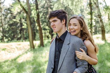 loving couple hugs in the park in the morning on the background of spring trees.lifestyle of people of happiness. The Laughing Girl Behind the Guy