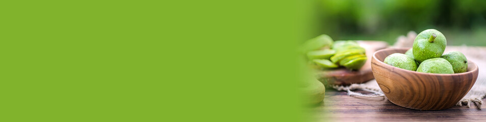 Banner ingredients for tincture of green walnuts in a wooden ecological plate without chemicals. zero waste. Still life of nuts, wooden utensils.