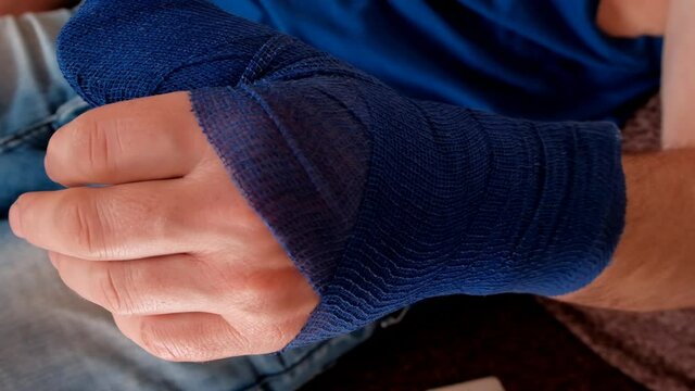 Blue surgical bandage on the arm. Medicine concept. Fractures and sprains. Surgical dressing. Broken arm. Bandaged hand. Bandages and bandages. 4k footage