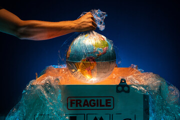 An employee takes a valuable cargo out of a wooden box, a concept for the delivery of a fragile or valuable cargo. A man takes out a globe or earth from a box
