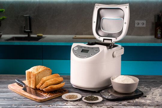 the bread maker is on the kitchen table. Homemade bread