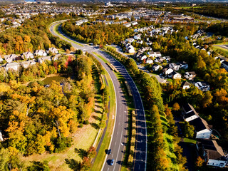 Panorama of residential quarters of a small town among the green forest along the highway.