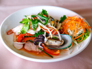 Thai sour spicy seafood salad with Shrimp, fish, octopus, squid and vegetables, Thai cuisine Yum Woon Sen, Yum talay