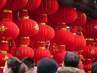 People and the traditional red lantern for Chinese New Year in Shanghai. Chinese New Year Holiday and culture concept photo. People in the new year market. Purchasing decorations for Chinese new year