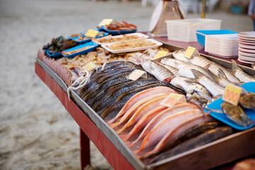 Freshly caught sea fish on the counter on the beach by the sea on a tropical island at sunset