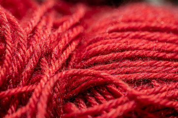 Red yarn macro view.  Abstract of cotton blend yard up close, with fibers going in multiple...