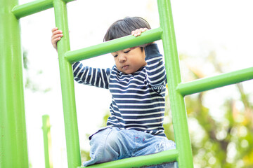 Obraz premium Jpyful asian boy climb on row in colorful playground