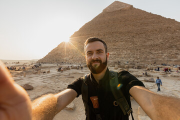 Selfie of a young man with the pyramid on the background, Cairo, Egypt - obrazy, fototapety, plakaty