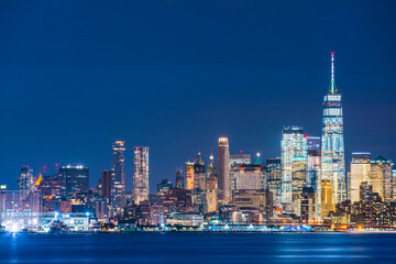 Obraz premium new york city skyline at night with reflection in hudson river.
