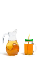 Refreshing, summer drink made kombucha in jug and mug with straw on white background.